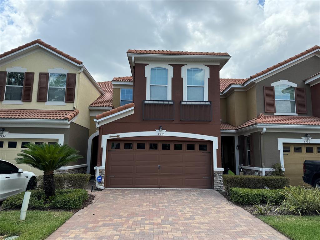 a front view of a house with a garden and garage