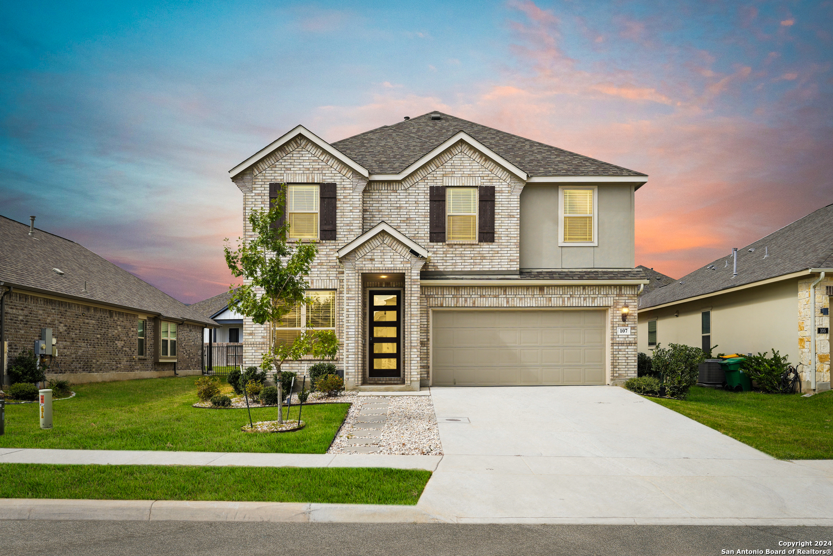 a front view of a house with a yard and garage