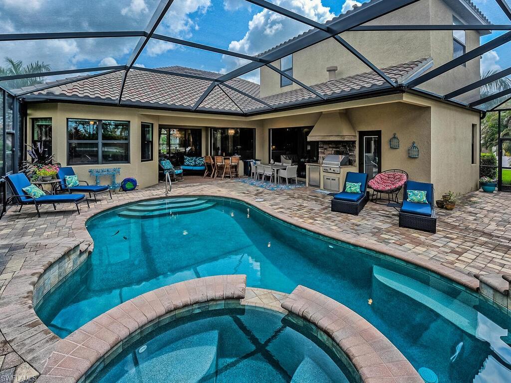 a living room with stainless steel appliances granite countertop a sink a table and chairs