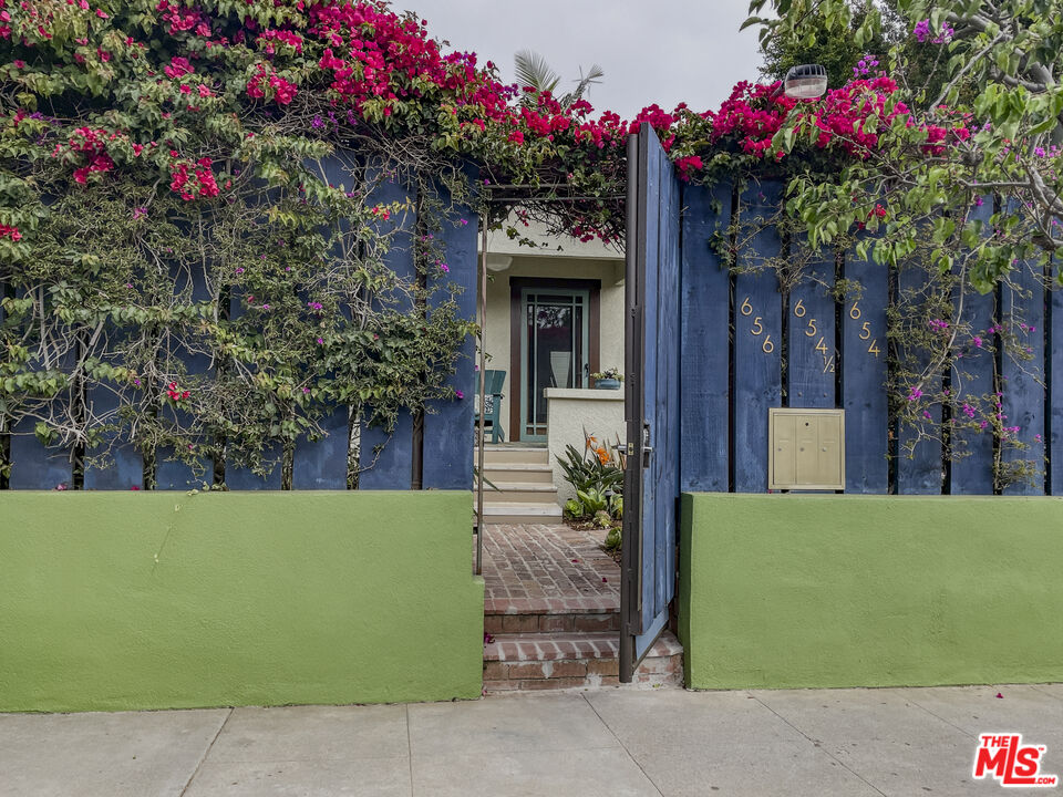 a front view of a house with a lot of flower plants