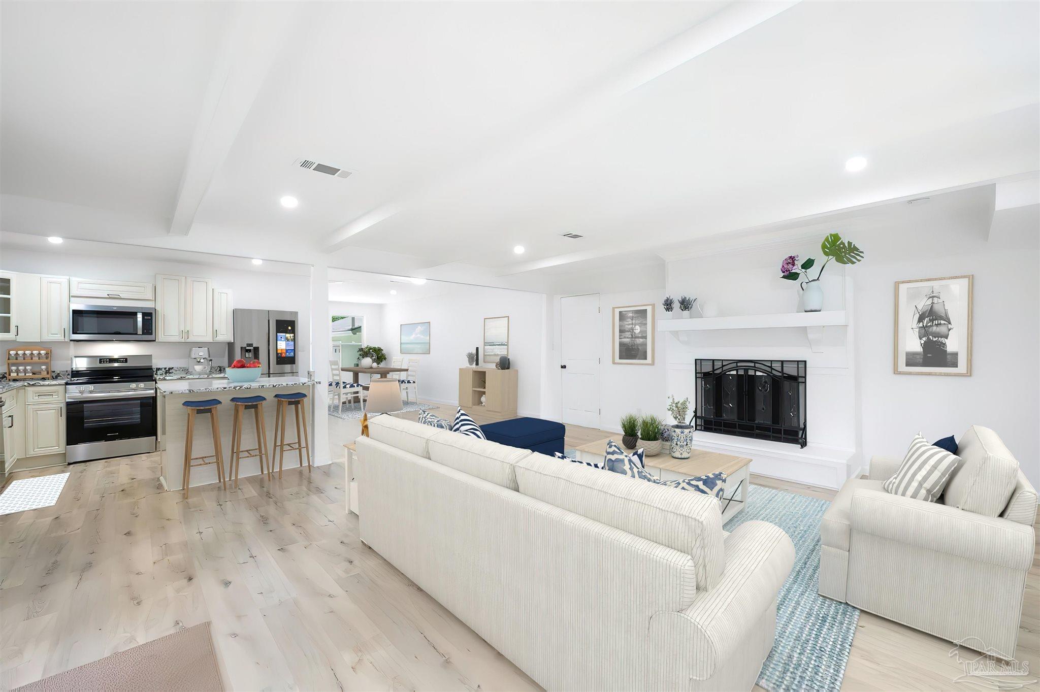 a living room with furniture a fireplace and a kitchen view