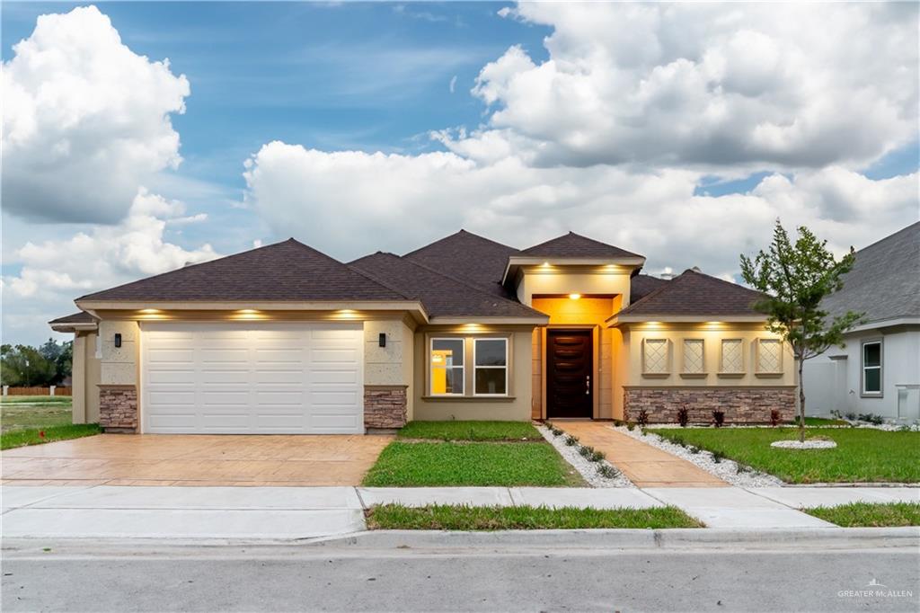 Prairie-style home featuring a front lawn and a garage