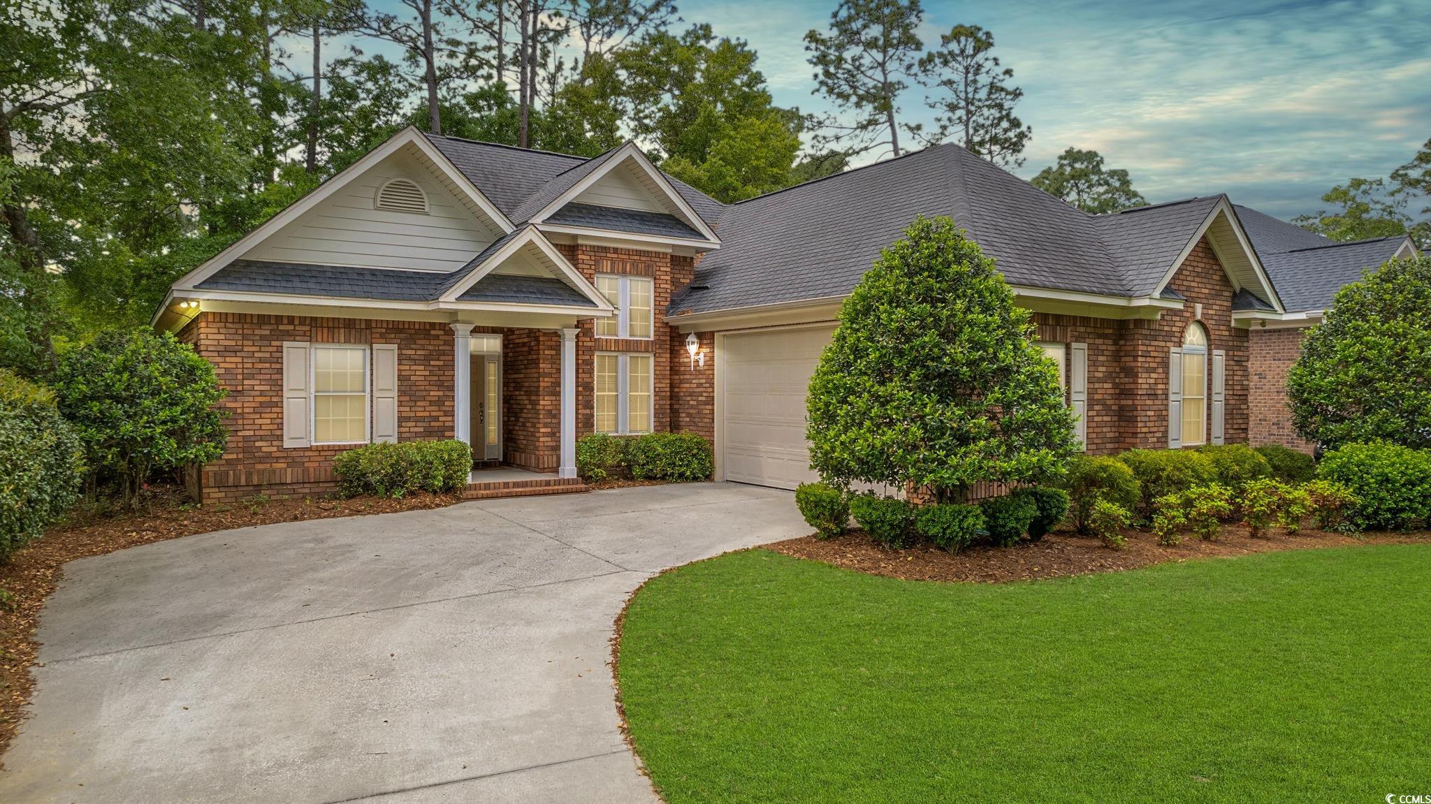 View of front of home with a front yard and a gara