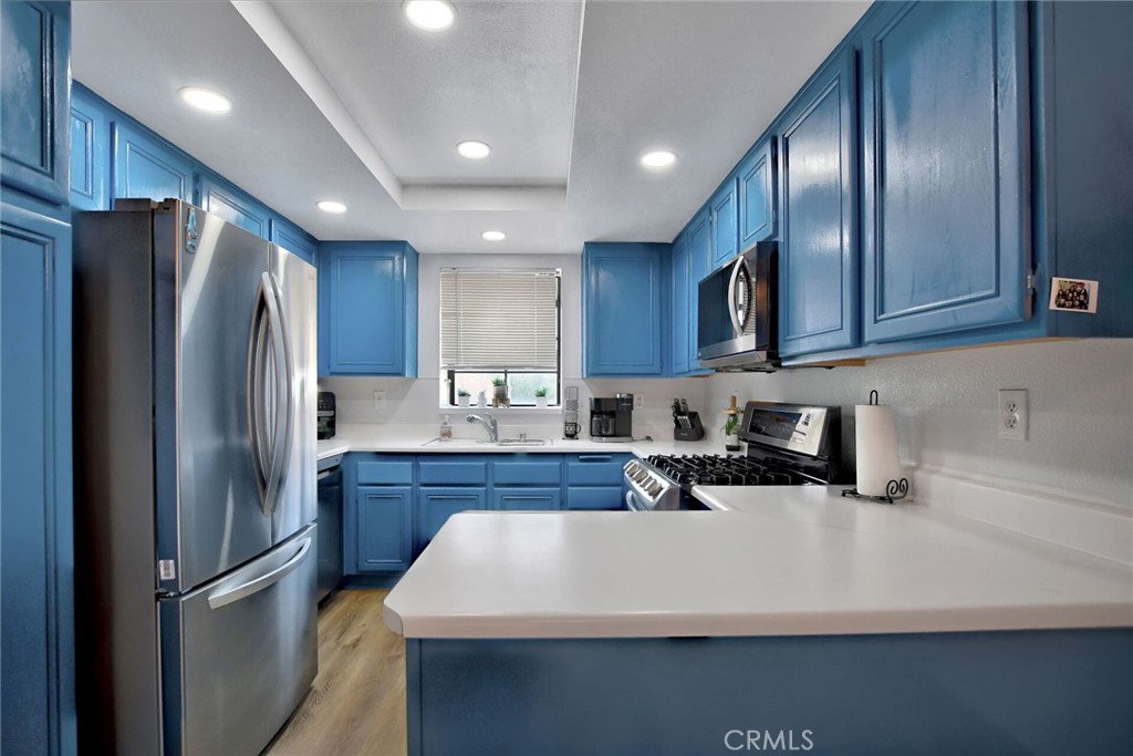 a kitchen with stainless steel appliances a refrigerator and wooden cabinets