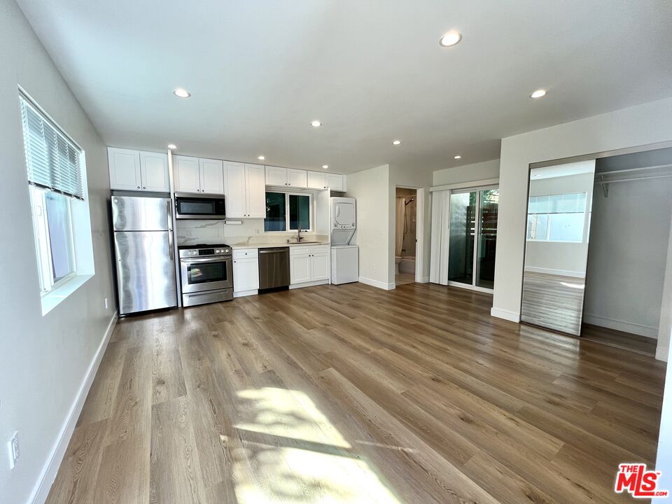 a view of kitchen with stainless steel appliances refrigerator stove microwave and cabinets