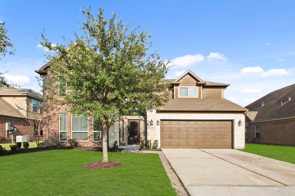 a front view of a house with a yard and garage