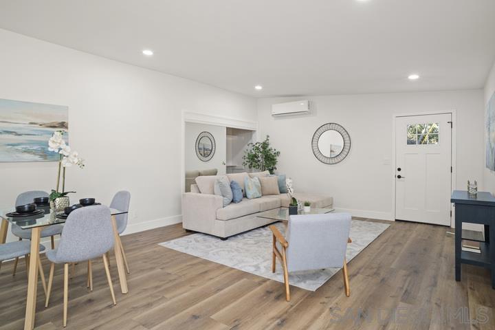 a living room with furniture a clock on wall and wooden floor