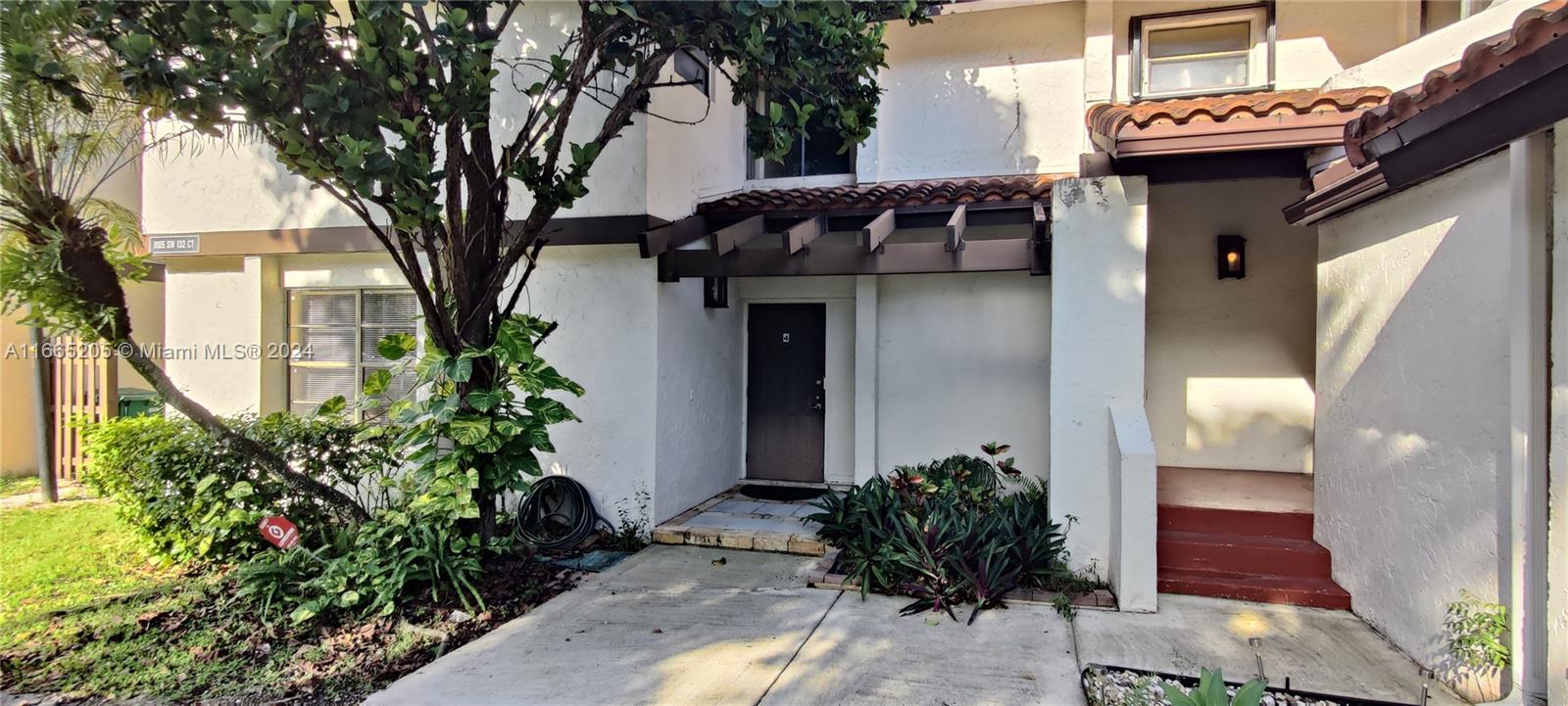 a house with potted plants in front of it