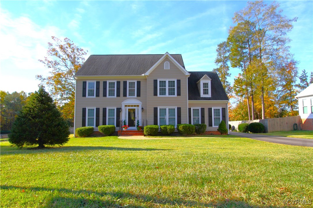 Colonial home with a front yard