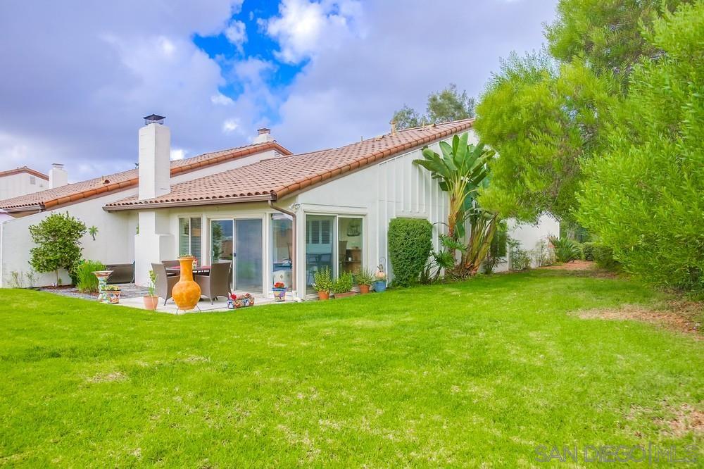 a view of a house with a yard and sitting area