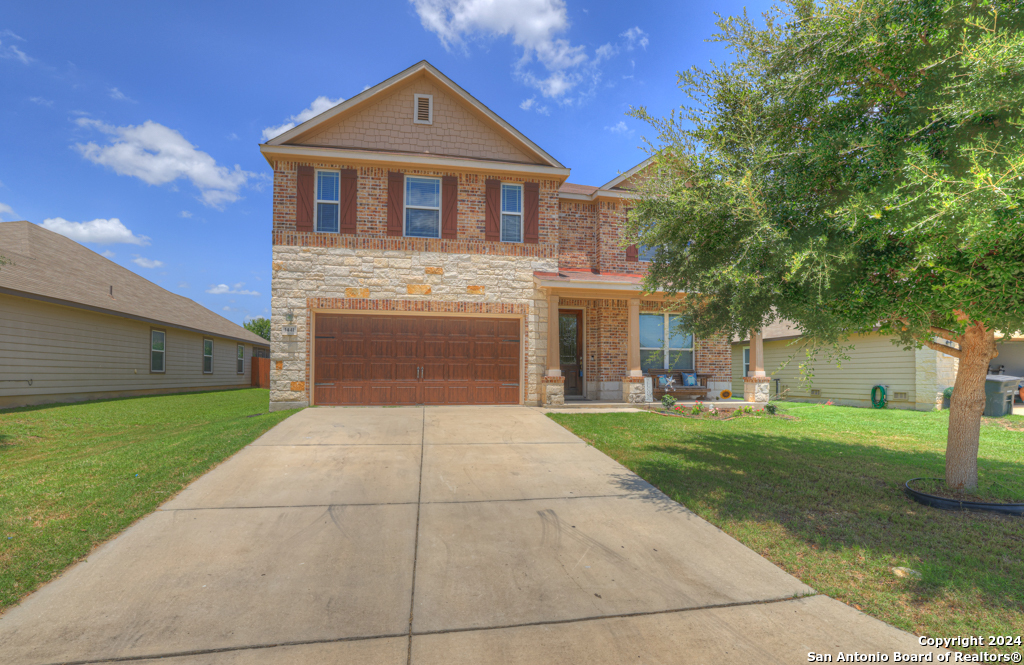 a front view of a house with a yard and garage