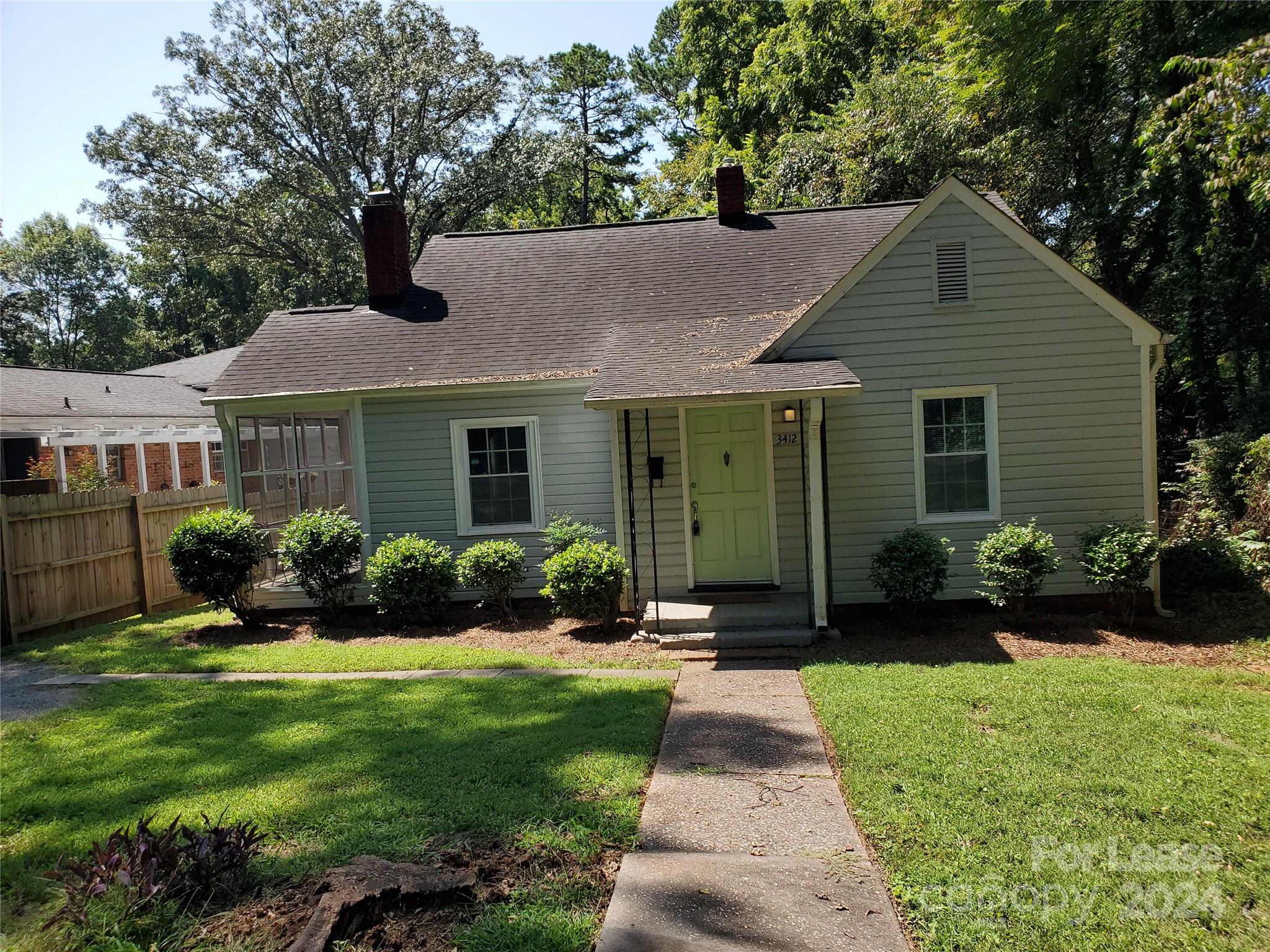 a front view of a house with a yard and potted plants