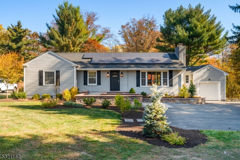 a front view of a house with a garden and trees