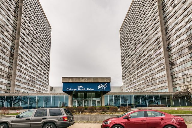 a front view of a building with cars parked