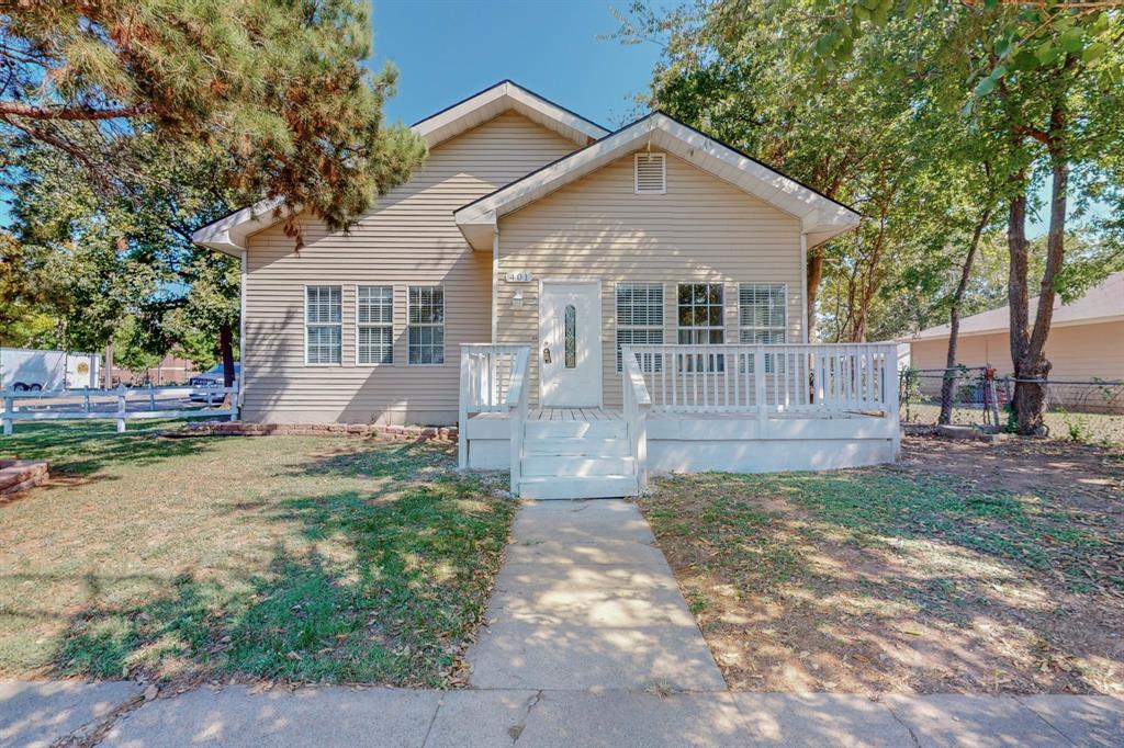 a front view of a house with a yard and trees