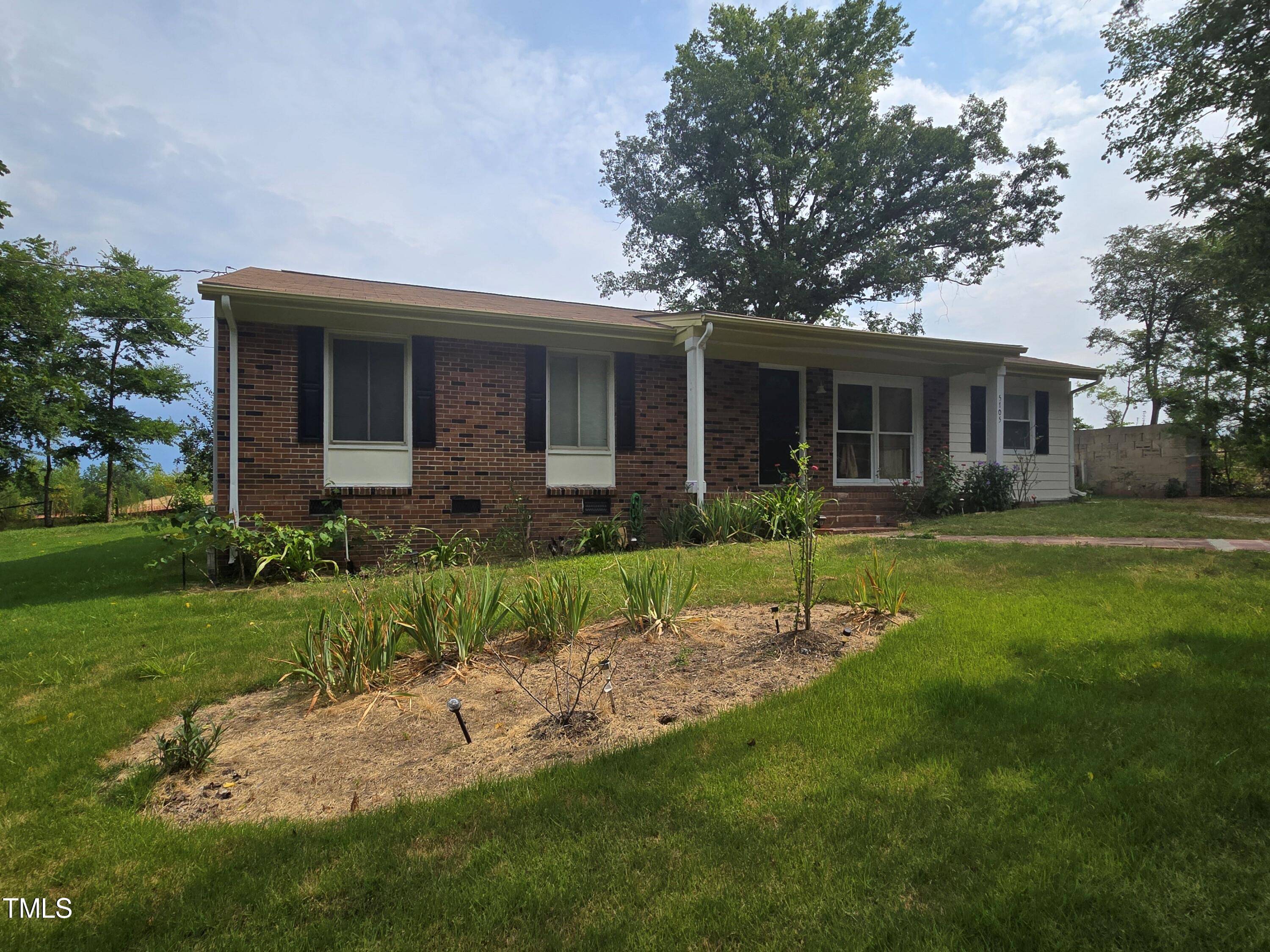 a view of a house with a yard and plants