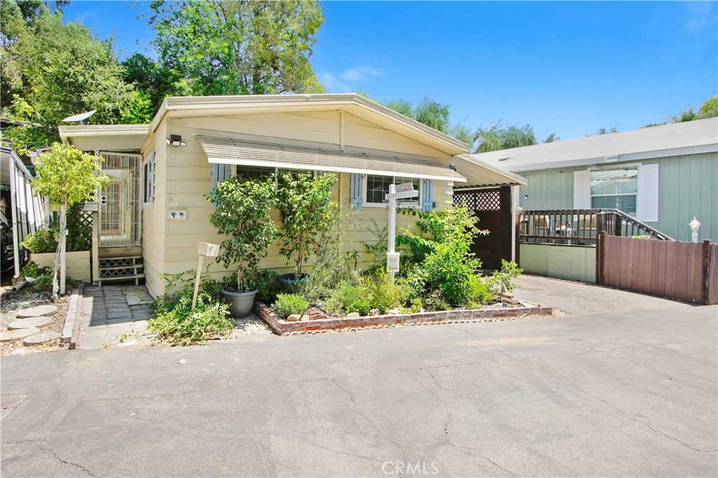 a front view of a house with a yard and potted plants