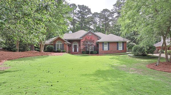 a front view of a house with yard and green space