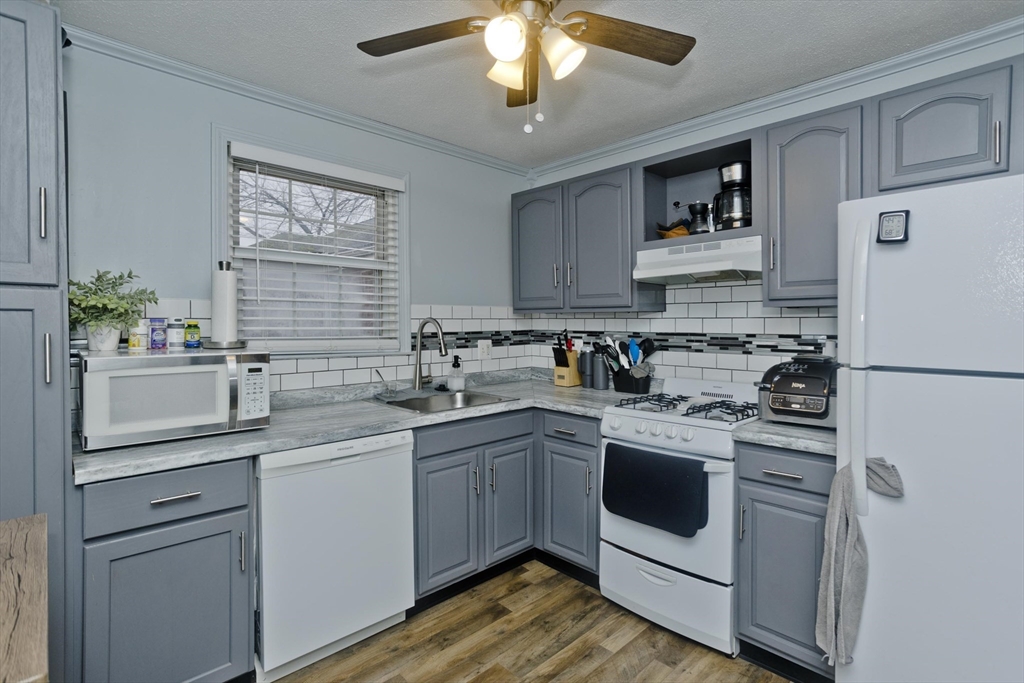 a kitchen with white cabinets and white appliances