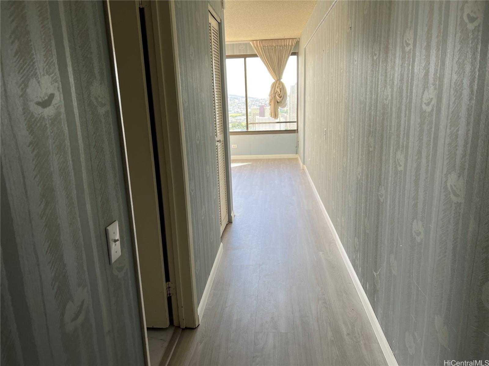 a view of a hallway with wooden floor and staircase