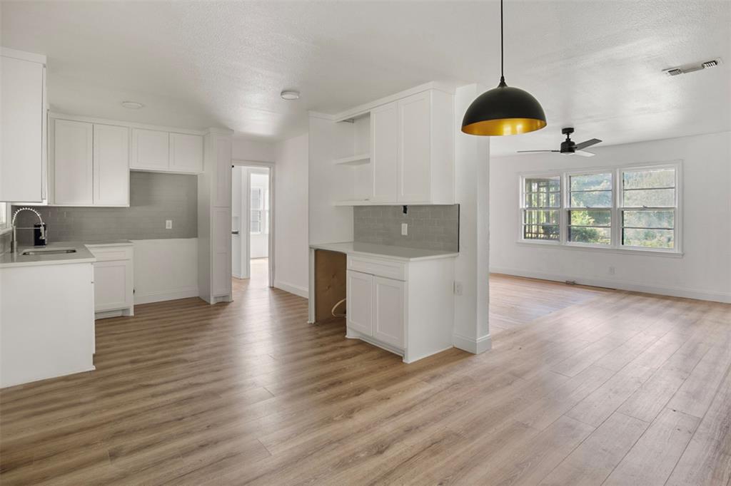 a kitchen with stainless steel appliances granite countertop a sink a stove a refrigerator and island with wooden floor