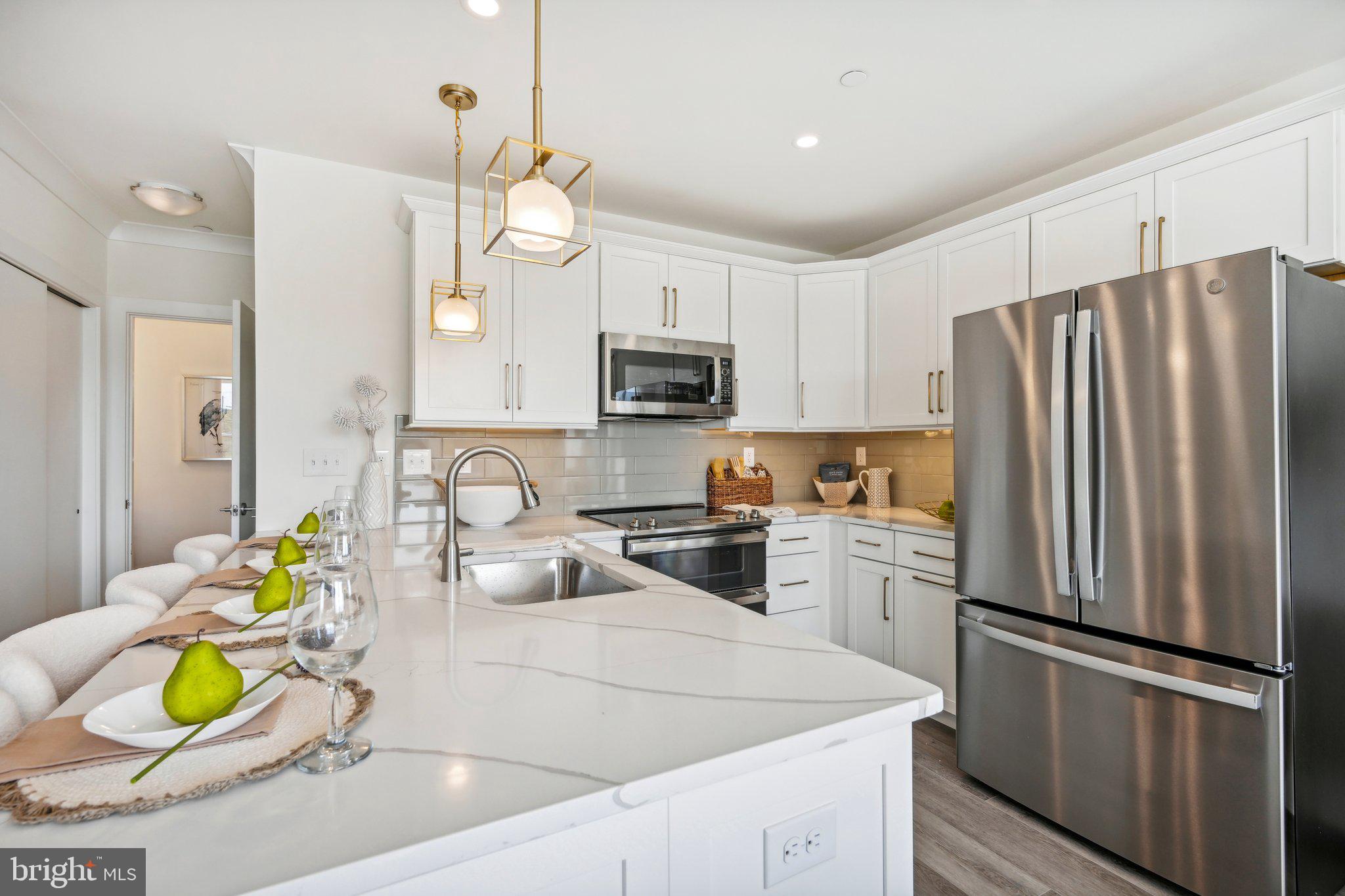 a kitchen with granite countertop a sink stainless steel appliances and refrigerator