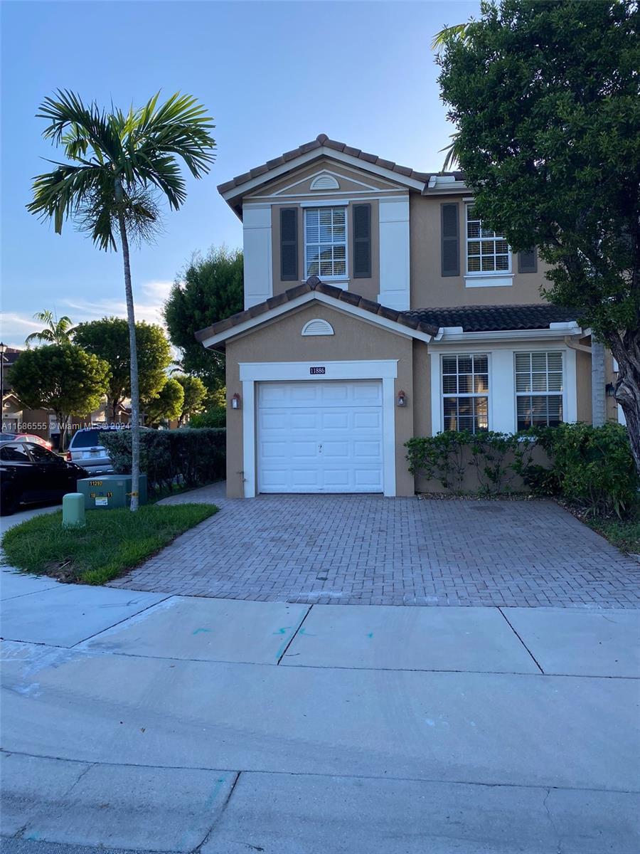 a front view of a house with a yard and a garage