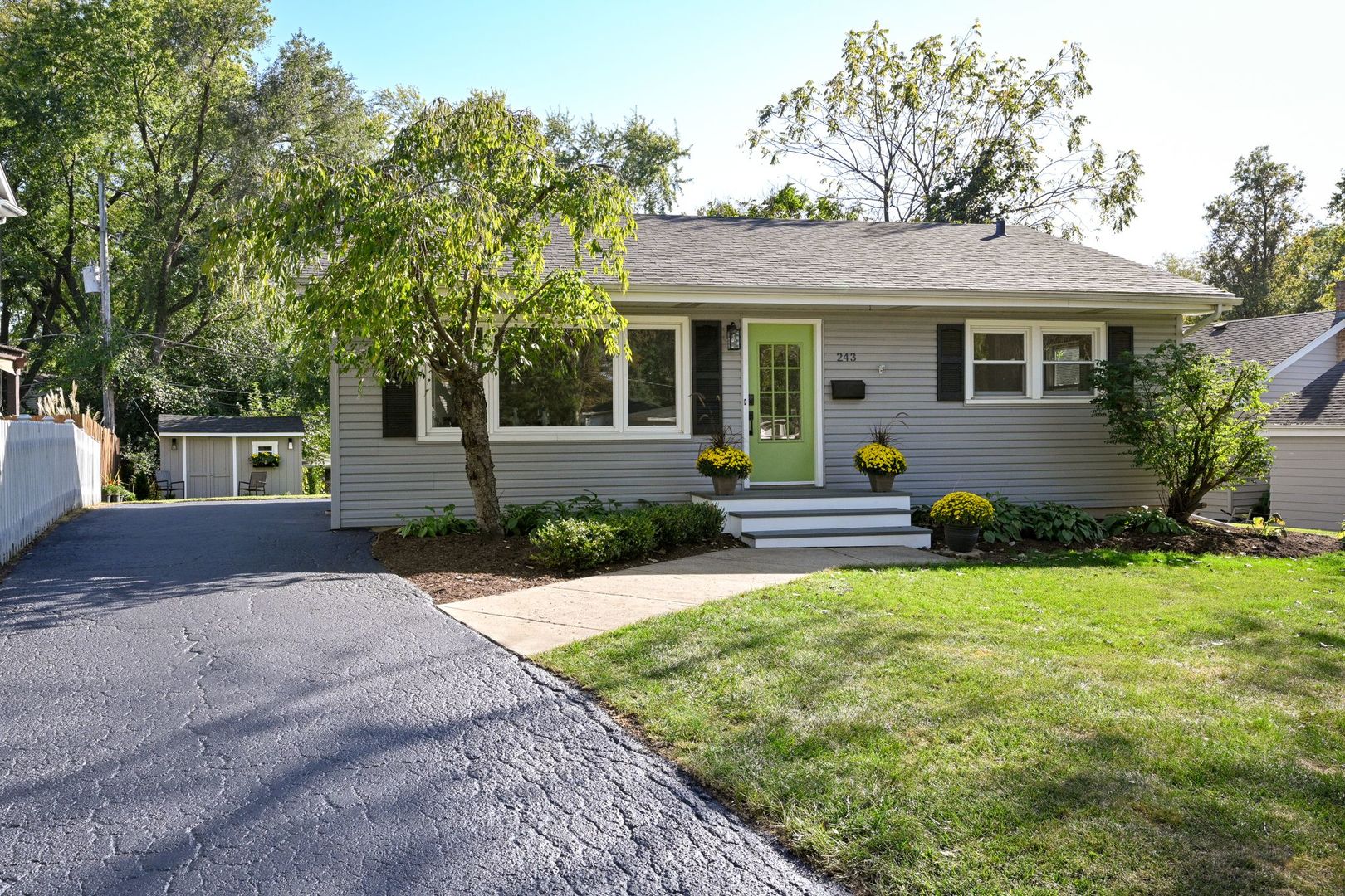 a front view of a house with a yard and potted plants