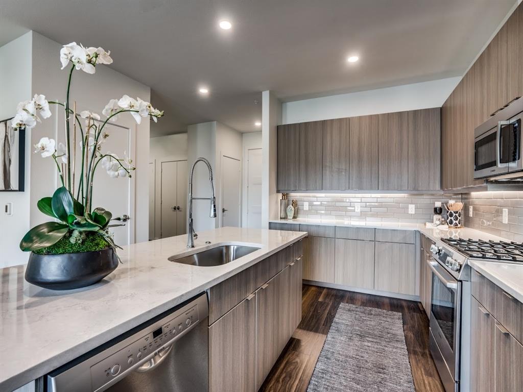 a kitchen with kitchen island granite countertop a sink stainless steel appliances and cabinets