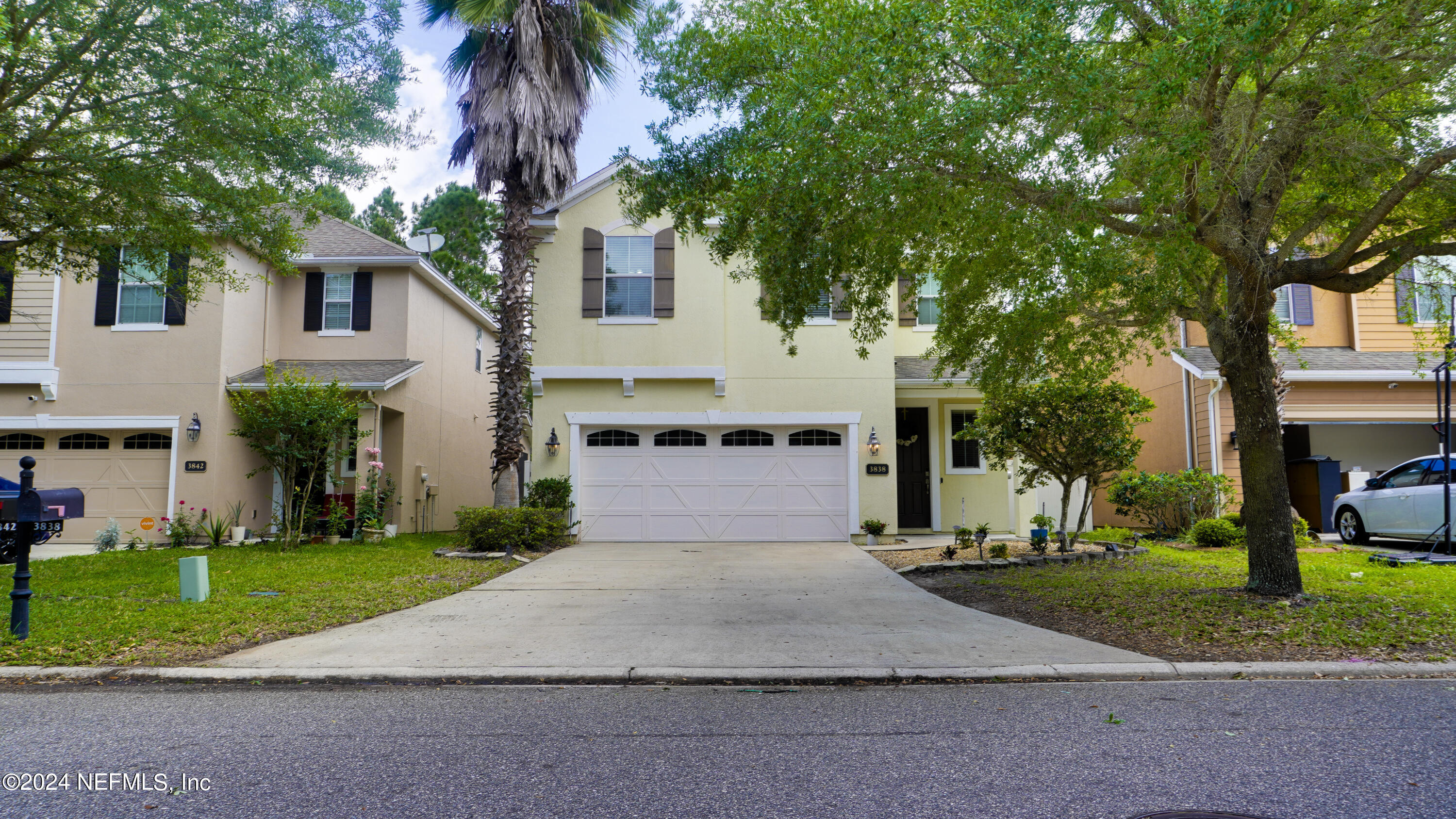 a front view of a house with a yard and trees