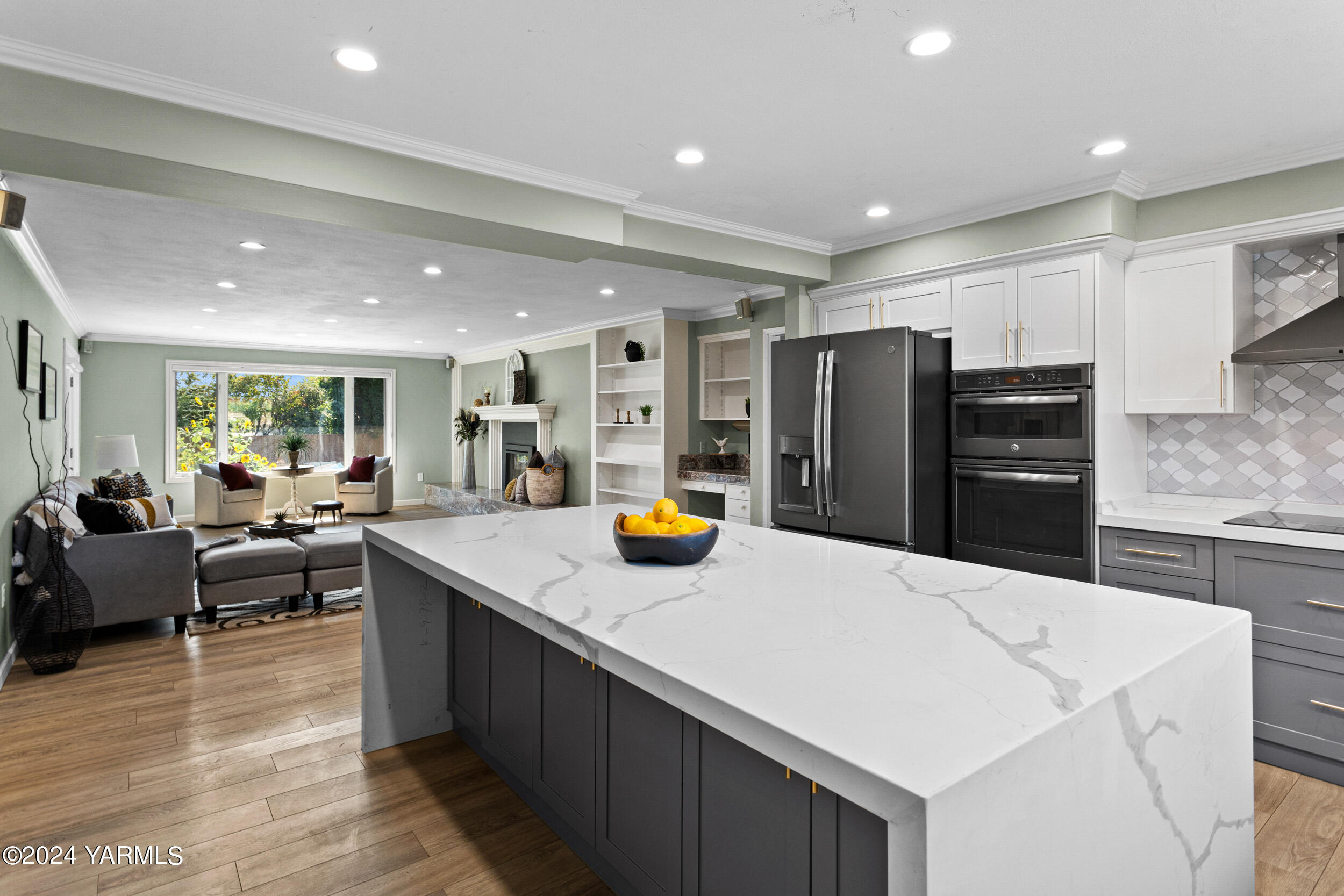 a kitchen with stainless steel appliances kitchen island granite countertop a refrigerator and a sink