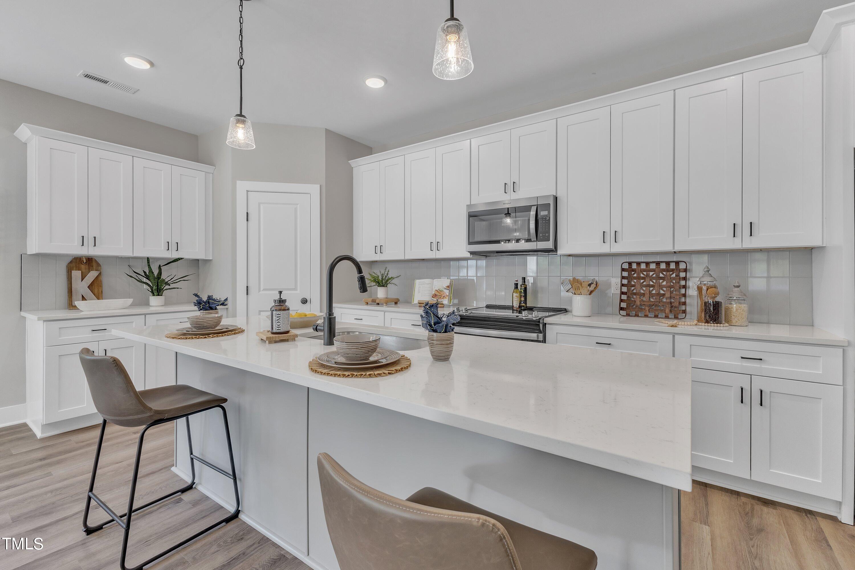 a kitchen with a sink white cabinets and white appliances