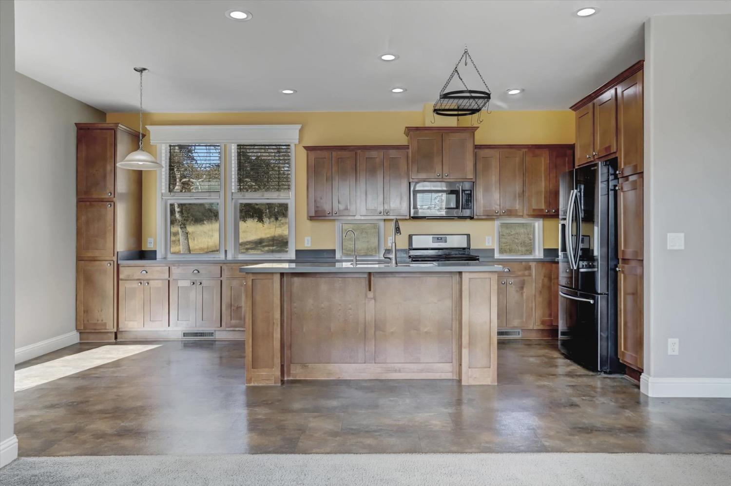 a kitchen with granite countertop a refrigerator and a stove top oven