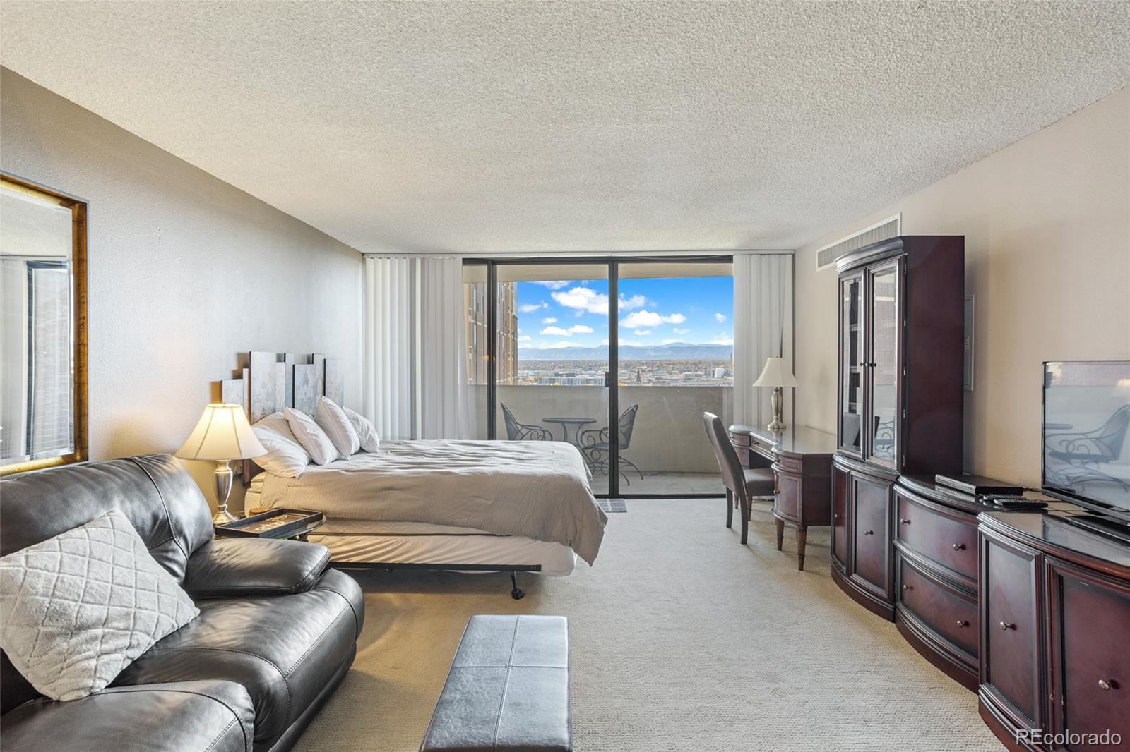 a bedroom with furniture and a flat screen tv