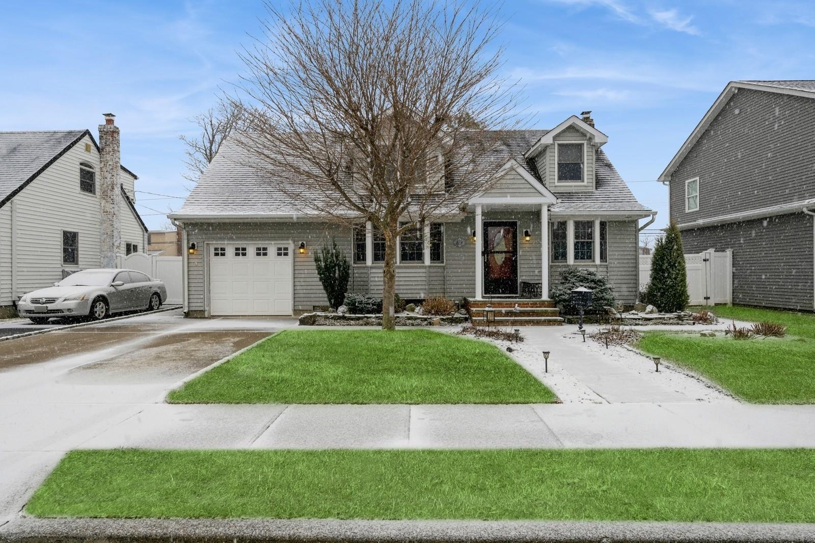 View of front of property with a front yard and a garage