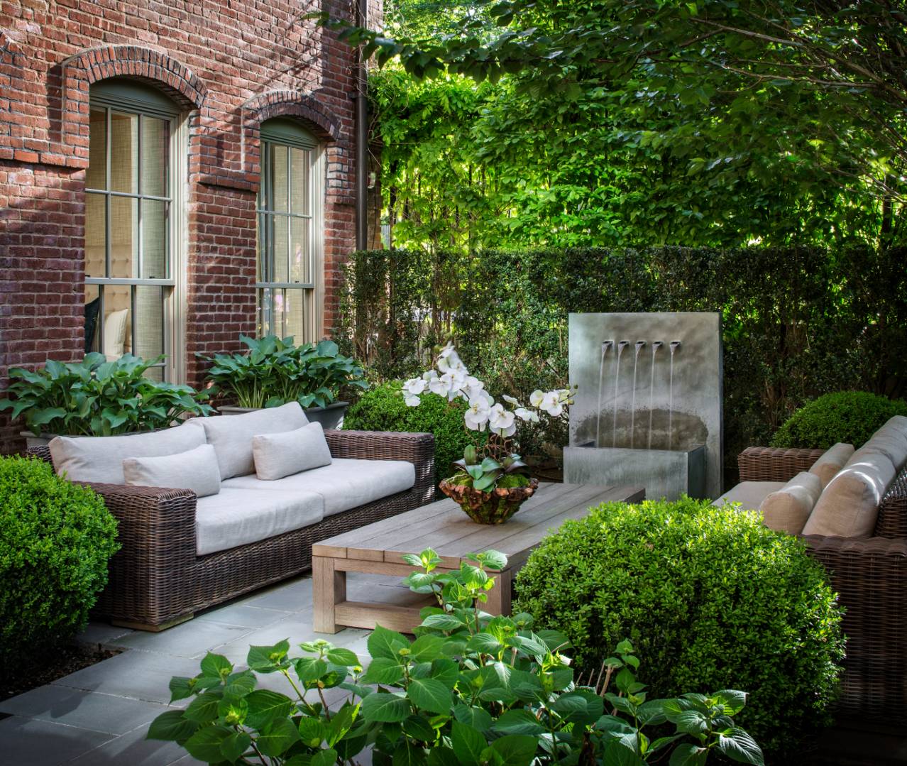 a view of a patio with couches table and chairs potted plants and a large tree