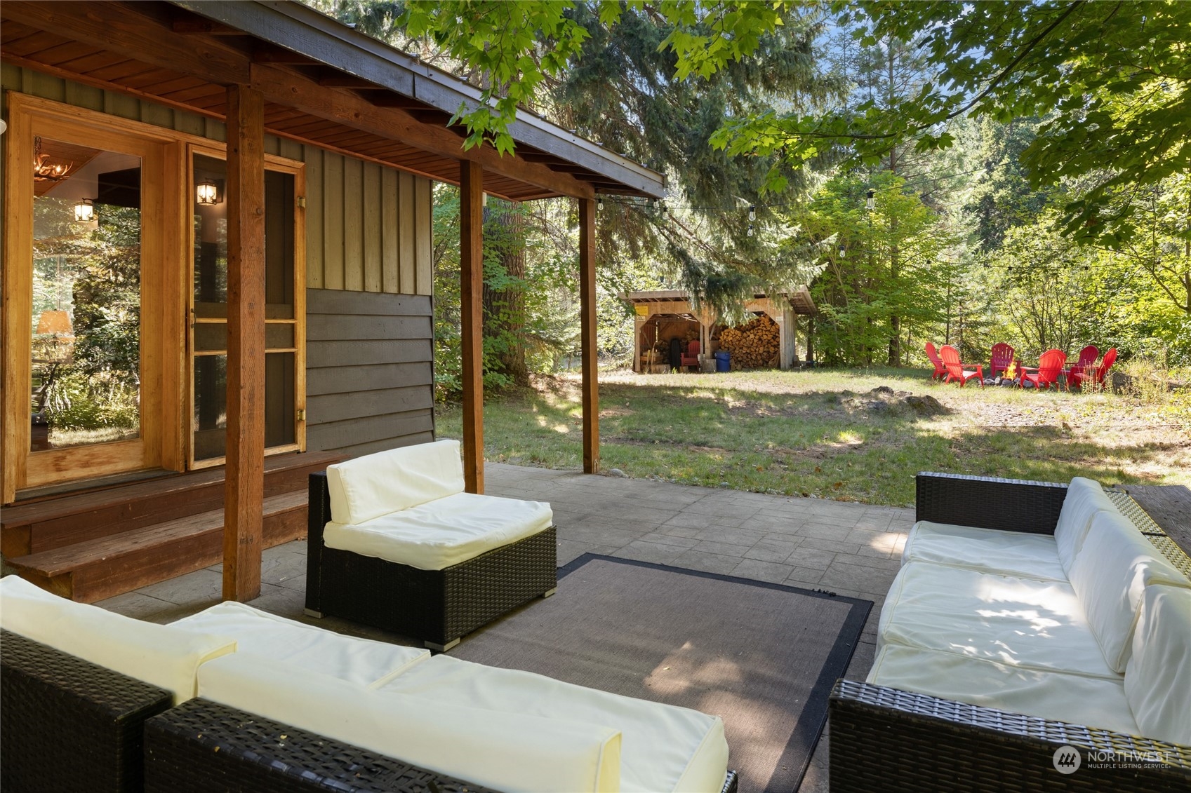 a view of a patio with couple of chairs and a fire pit