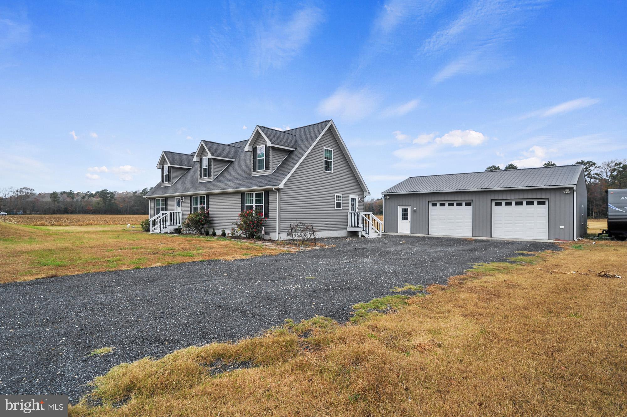 a front view of a house with a yard and ocean view