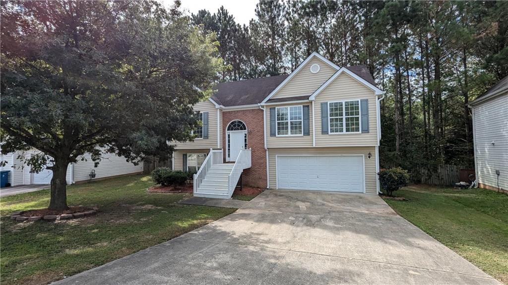 a front view of a house with a yard and trees