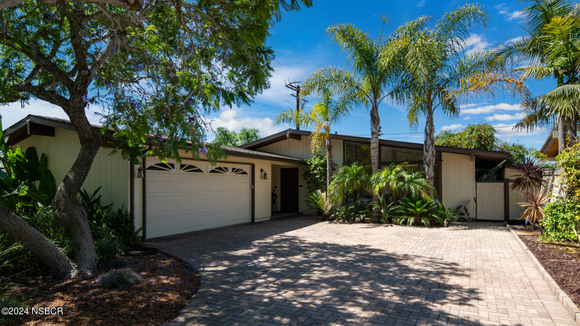 a view of a house with a yard and tree