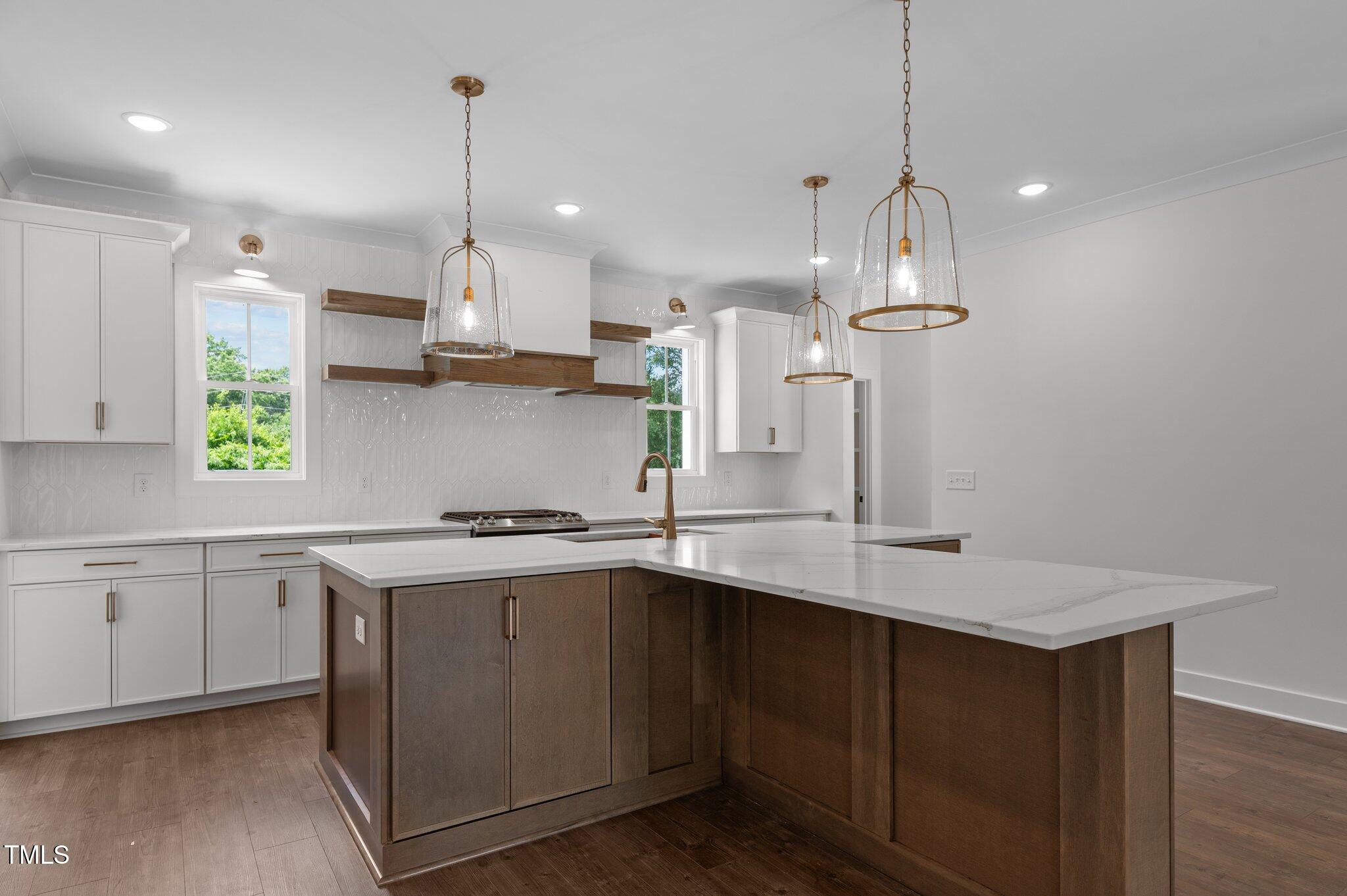 a kitchen with stainless steel appliances granite countertop a sink a stove a window and cabinets