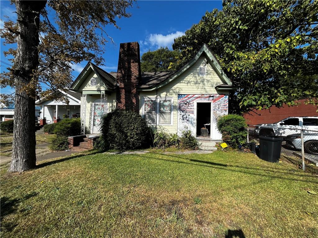 a front view of a house with a garden and trees