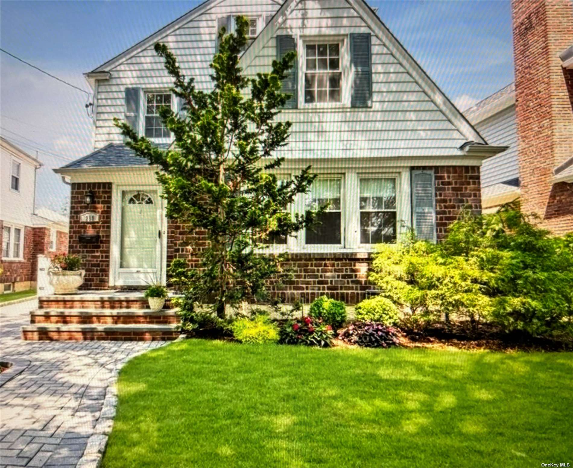 a front view of a house with a garden and plants