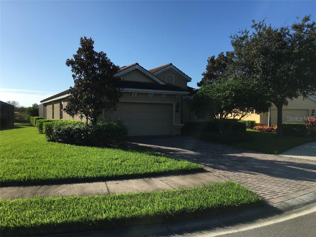 a front view of a house with a yard and a garden