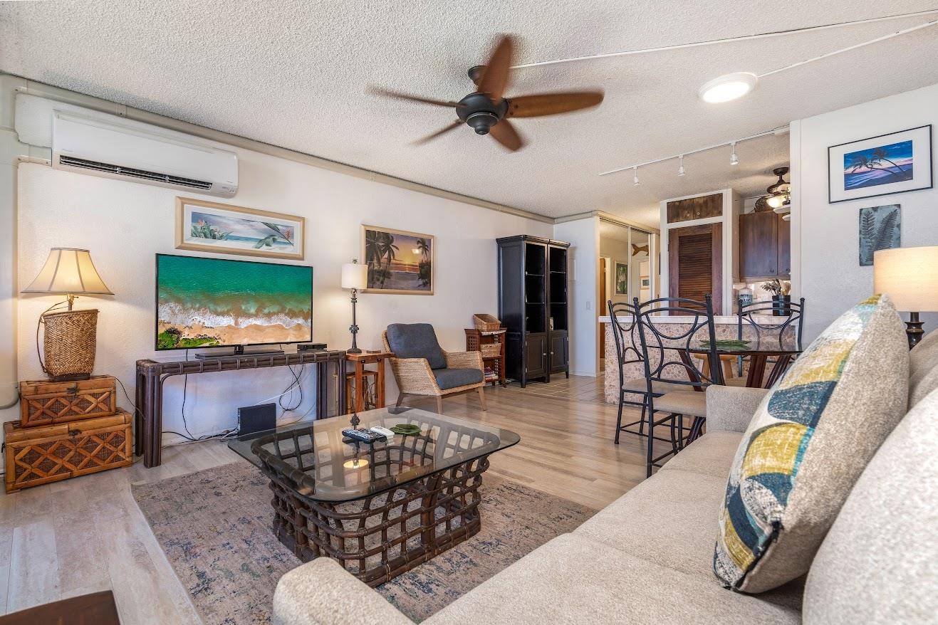 a living room with furniture kitchen view and a window