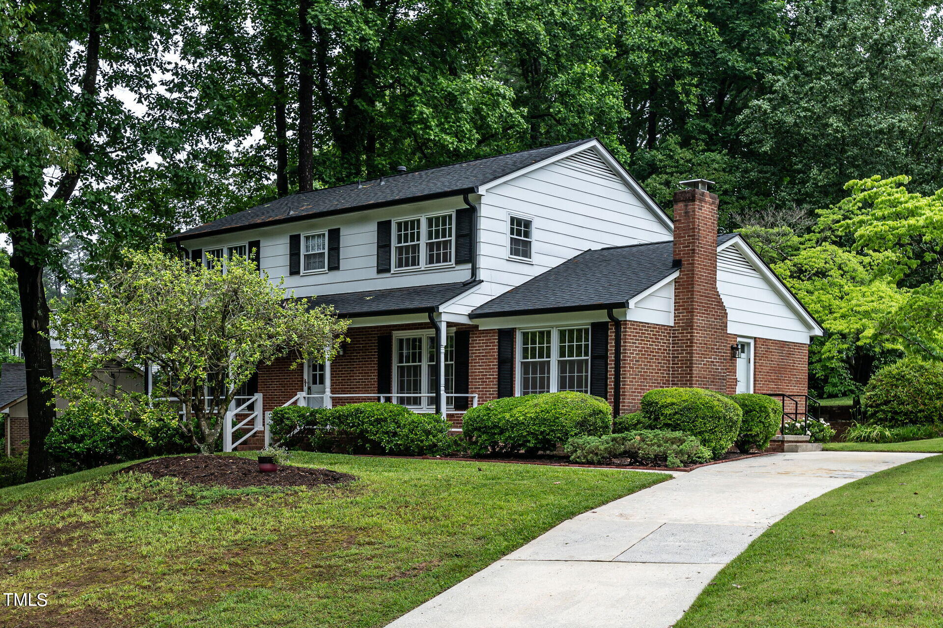 a front view of a house with a yard and trees