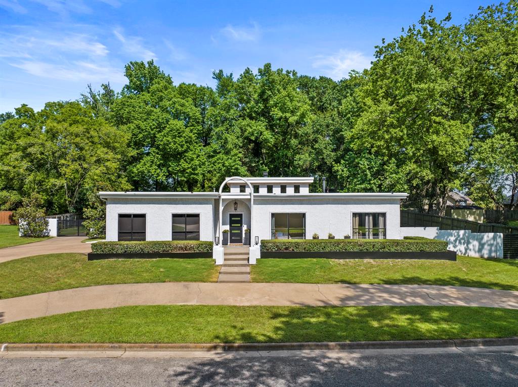 a front view of a house with a garden and yard