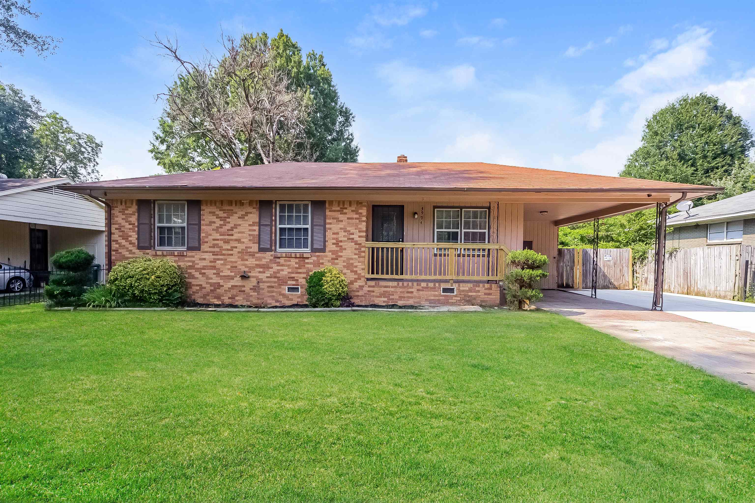 Ranch-style house with a carport and a front yard