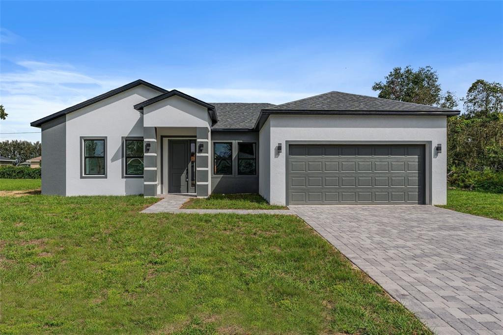 a front view of a house with a yard and garage