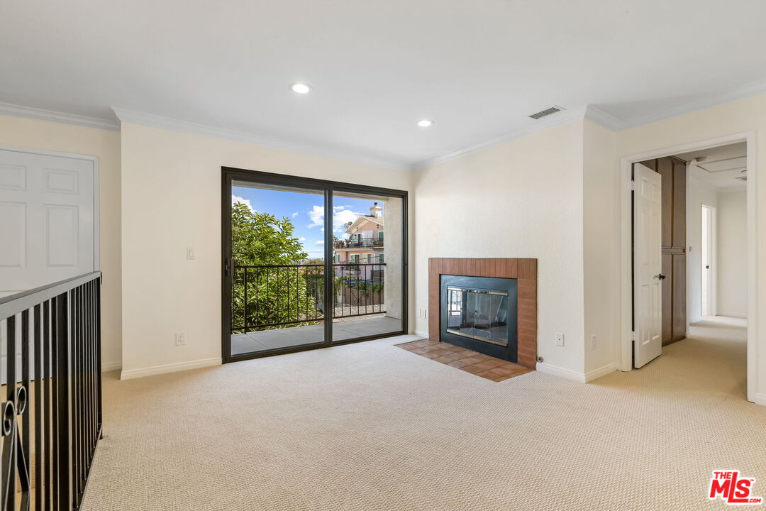 a view of an empty room with a fireplace and a window